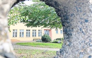 Blick durch den Betonzaun auf das jüngste Gebäude im Ensemble der Alte Schule Schenkenberg. Sie wird jetzt per Erbpacht von der Diakonie Delitzsch übernommen. FOTO: HEIKE LIESAUS